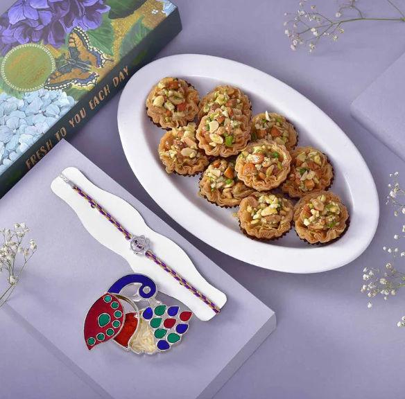 Silver Om Rakhi With Gourmet Roli Chawal Box N Baklawa Assortment